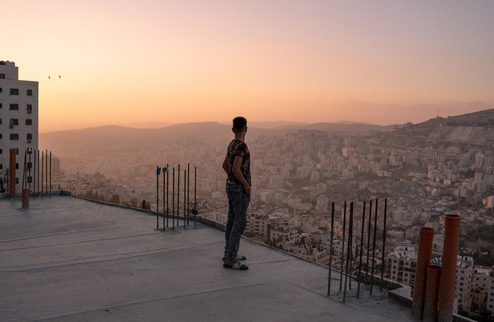 Un adolescent regarde le couché de soleil sur les hauteurs de Naplouse.